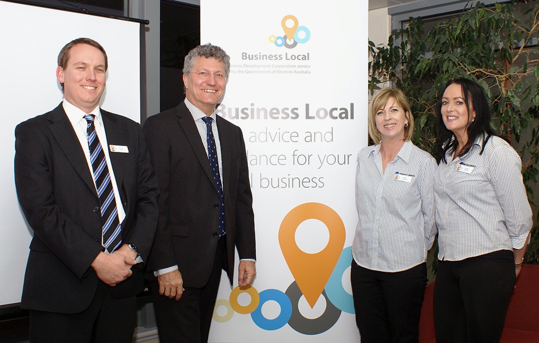 Photo of Small Business Commissioner David Eaton with staff and stakeholders in front of a Business Local branded banner.